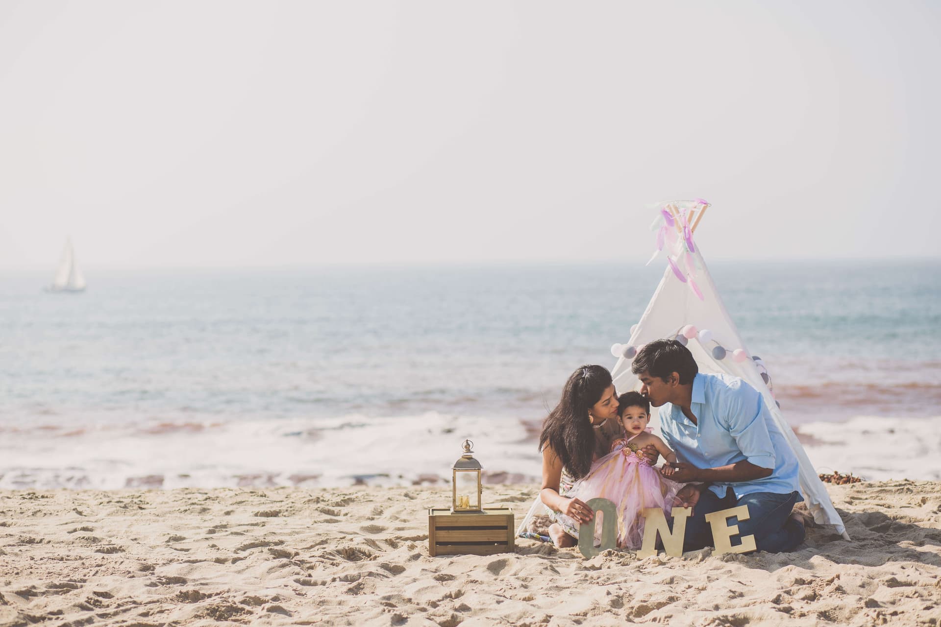 parents and toddler celebrating a birthday on a beach