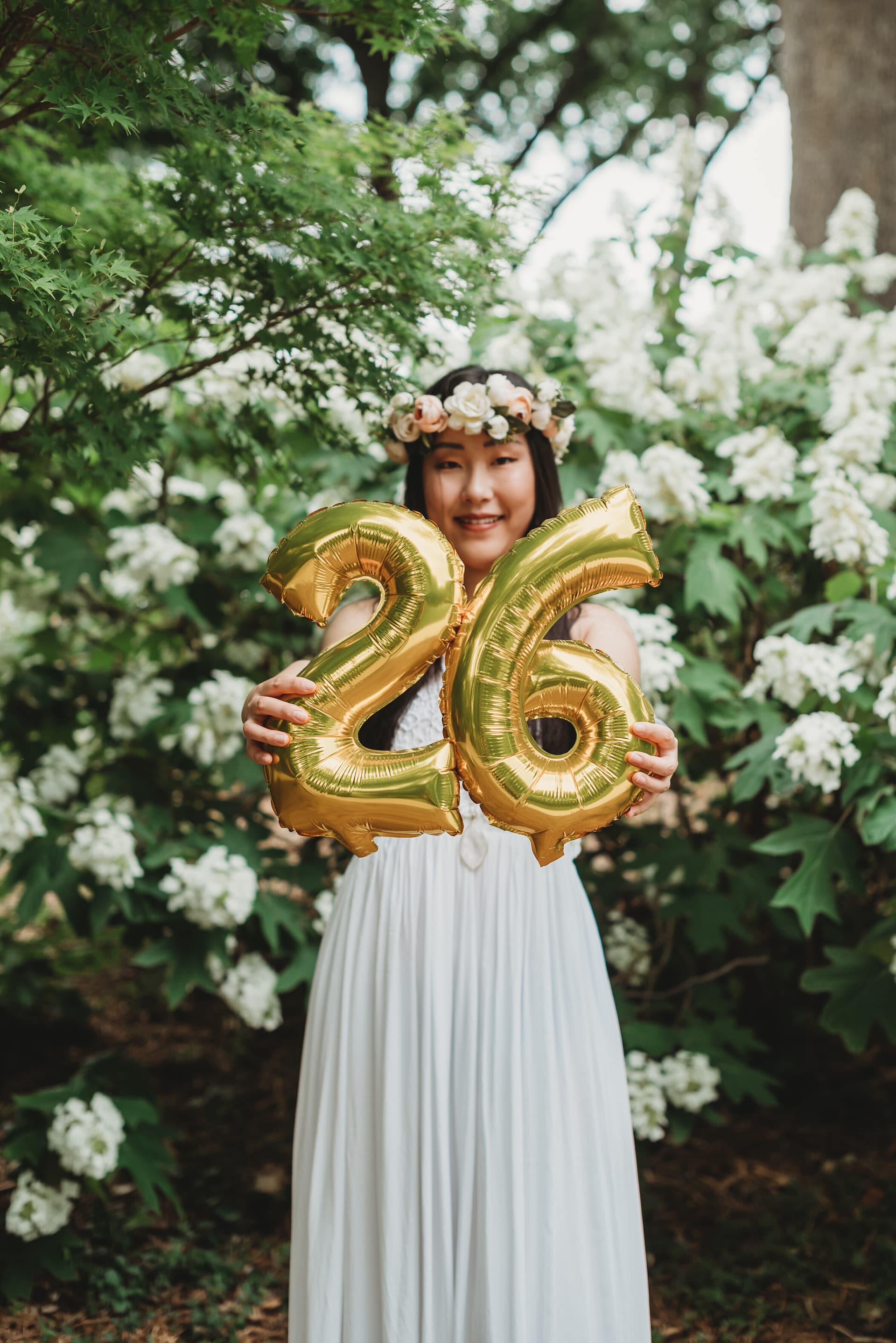 Birthday portrait holding milestone number balloons