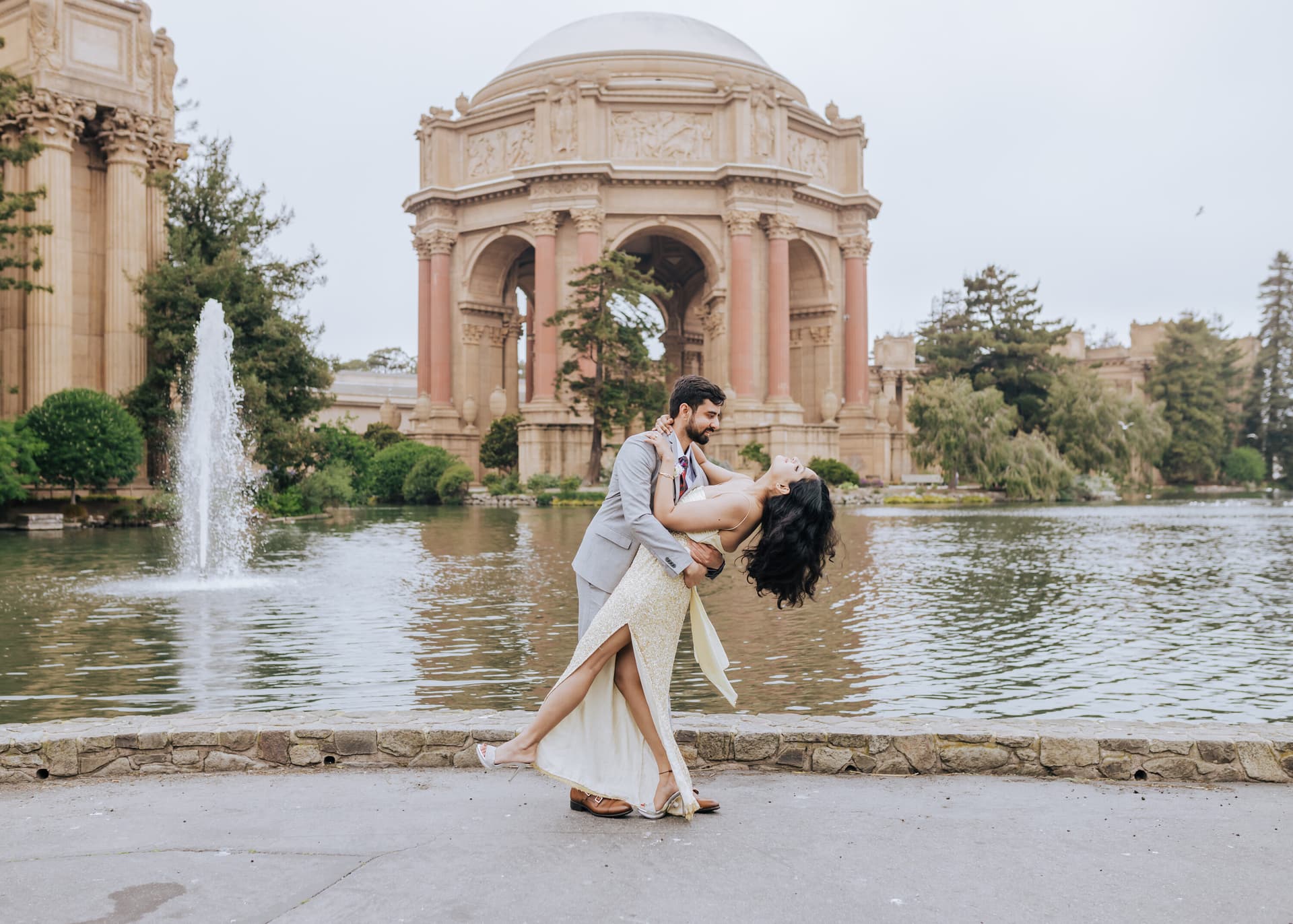 Couple dancing near a fountain at golden hour