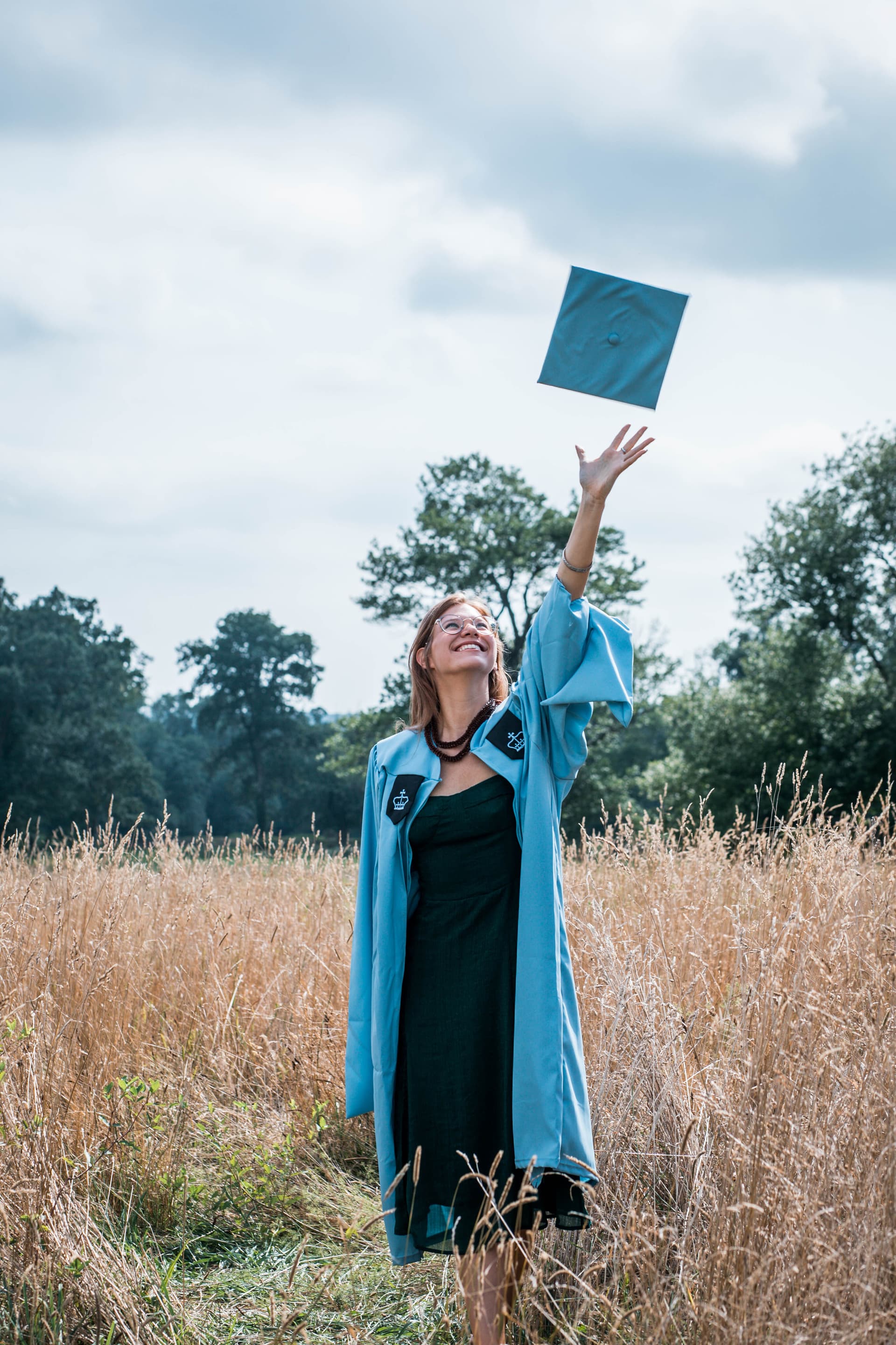 Graduate tossing a cap in the air during an outdoor session