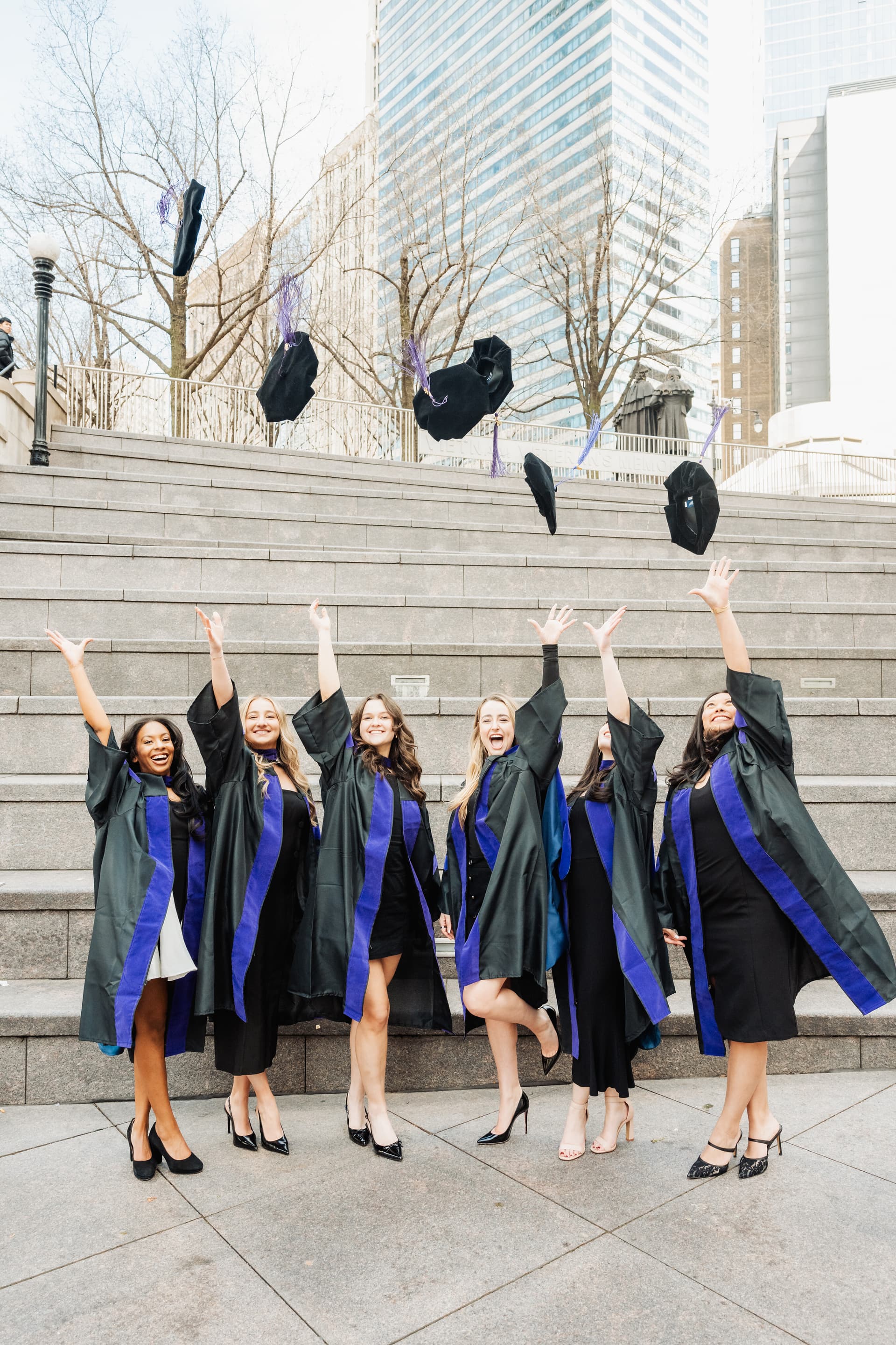 Group of graduates tossing caps on steps