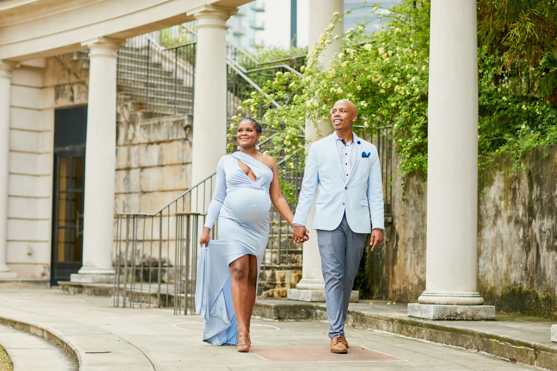 Expecting couple walking together in coordinated outfits