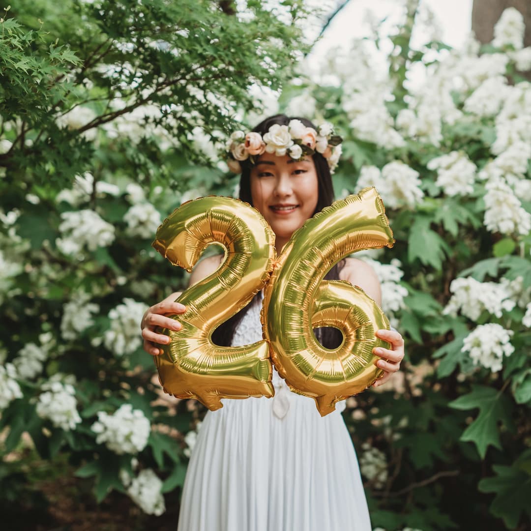 a woman holding an inflatable number 26
