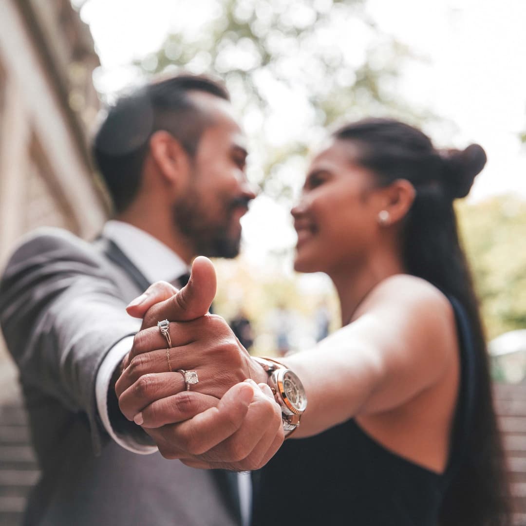 man and woman holding hands showing an engagement ring