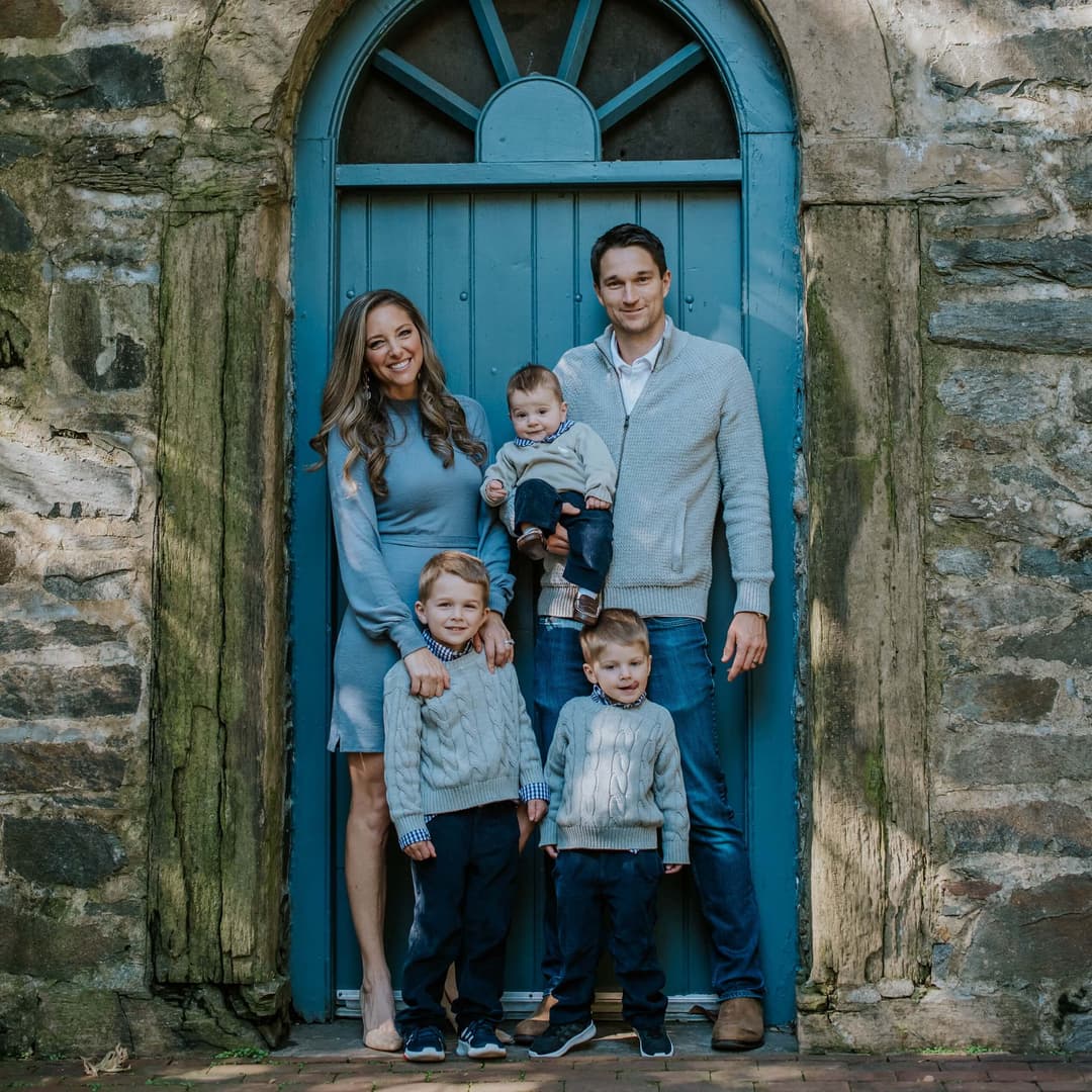 family with three kids in front of a blue door