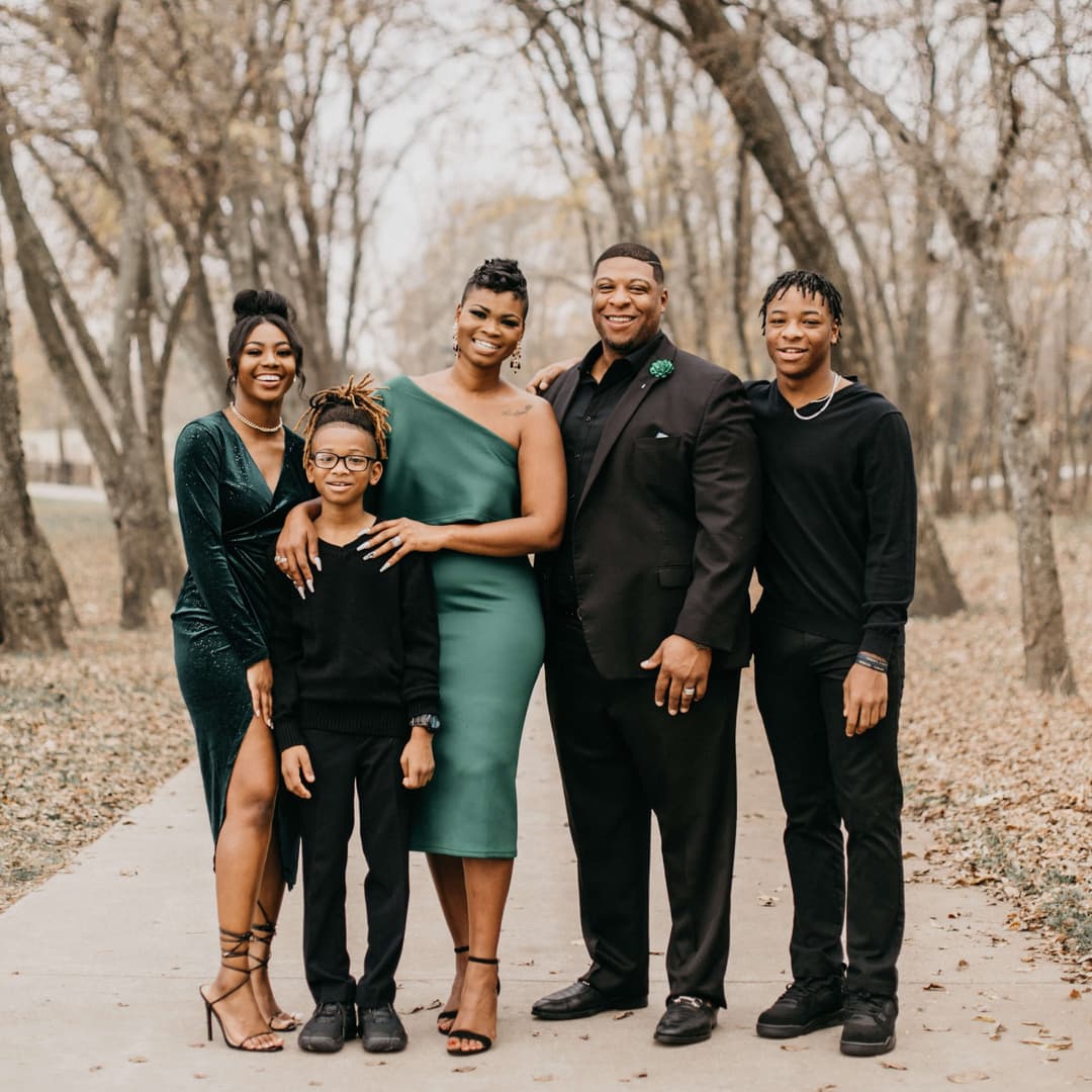 smiling family posing on a forest path