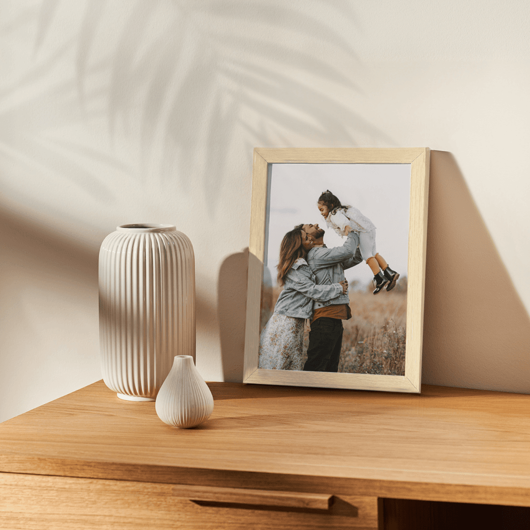 Paper Culture framed family print displayed on a wooden table beside a vase