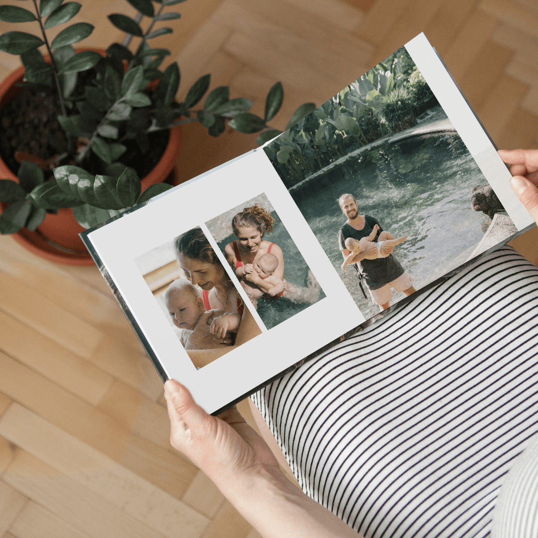 Person holding an open Paper Culture photobook showing family lifestyle photos