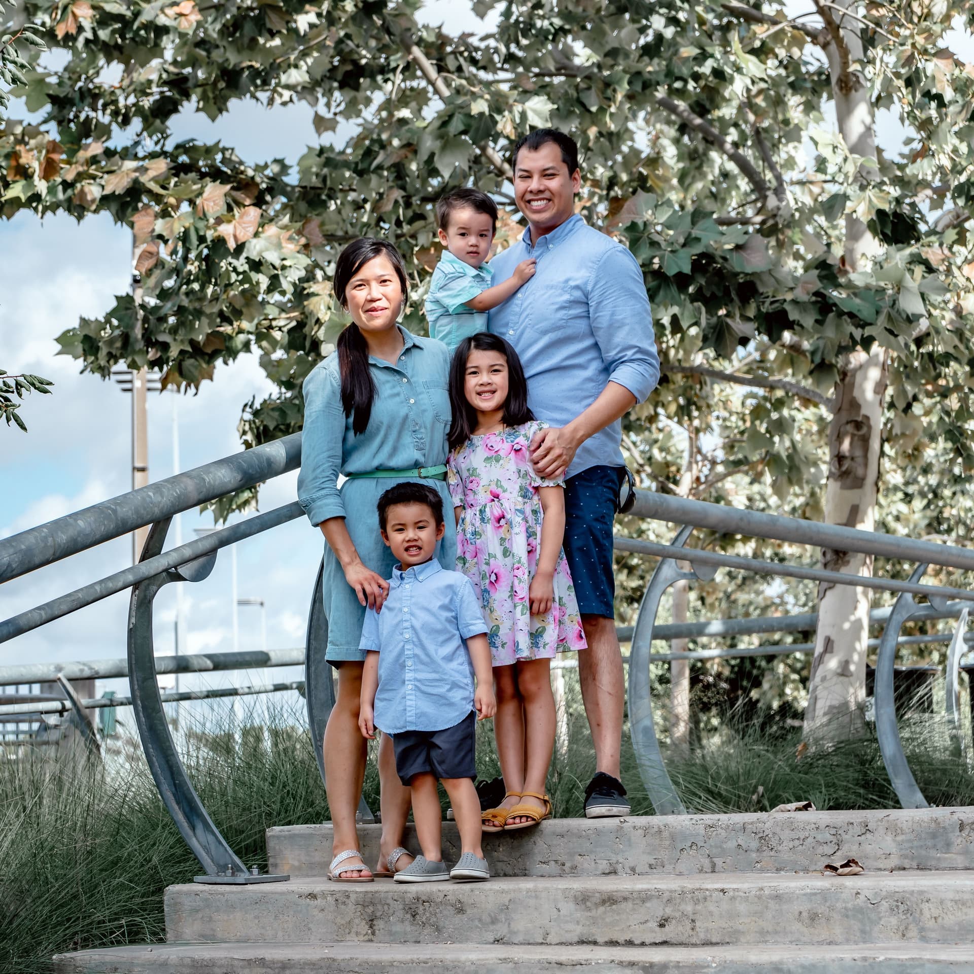 Family poses at the top of the stairs for their free outdoor park photoshoot