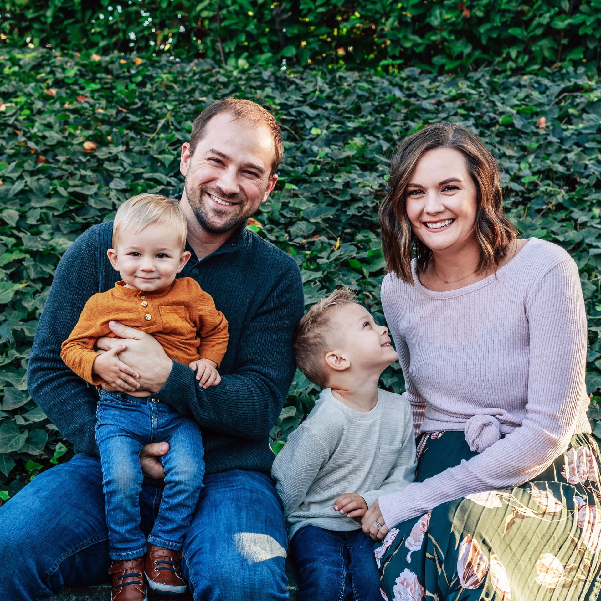 Family with two kids sits on park bench for their free outdoor park family photoshoot