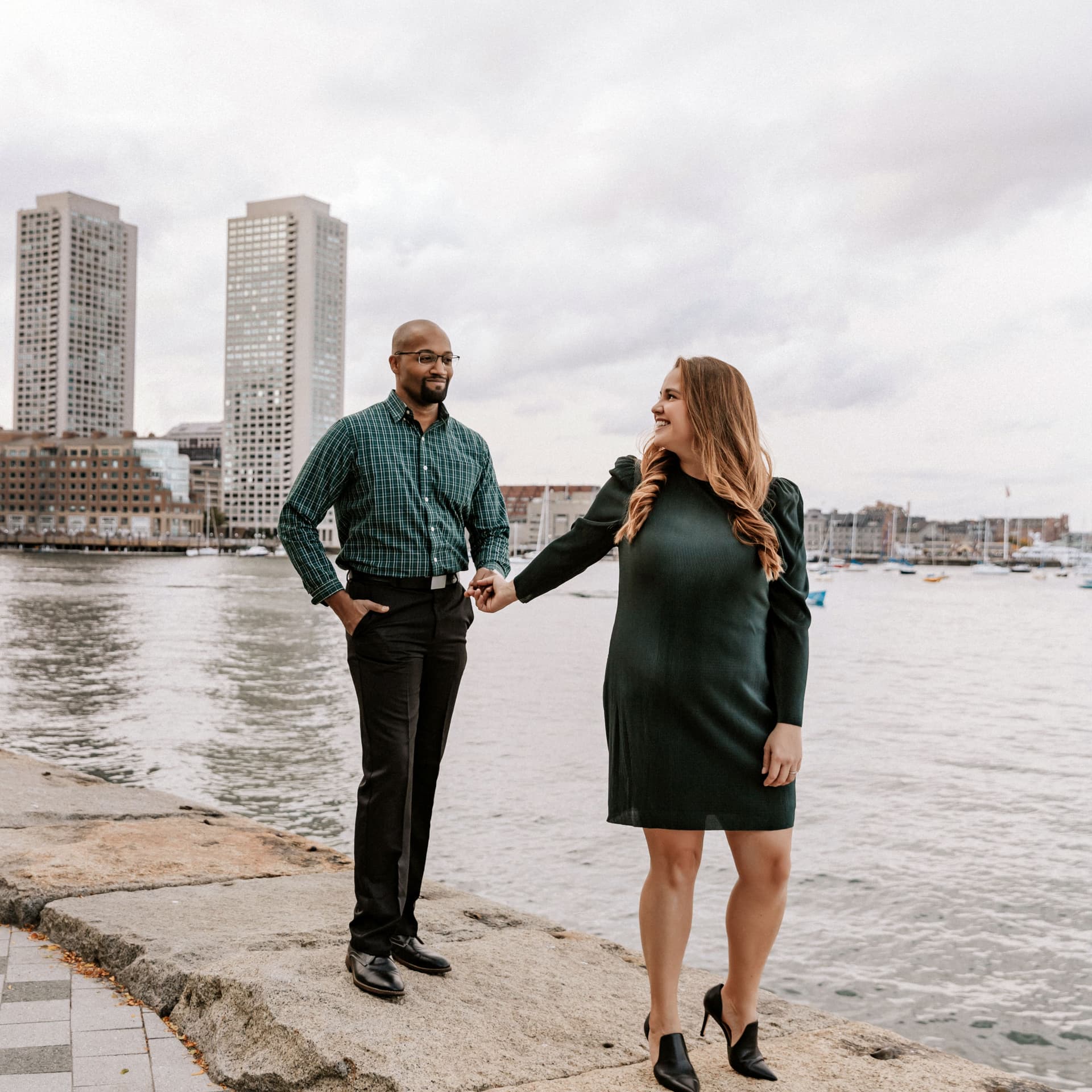 Couple holds hands walking down city pier for their free outdoor photoshoot