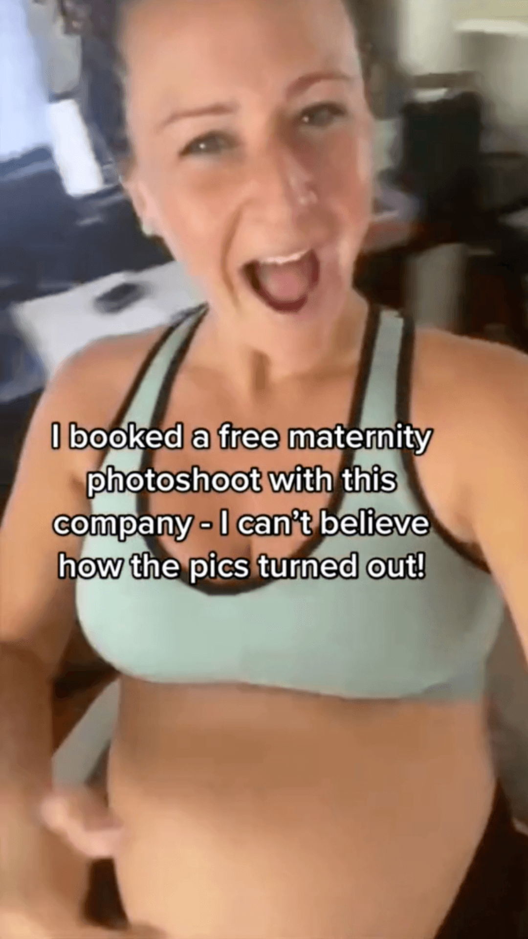 Pregnant woman in a sports bra smiling and excitedly gesturing to her belly with text overlay about a maternity photoshoot.