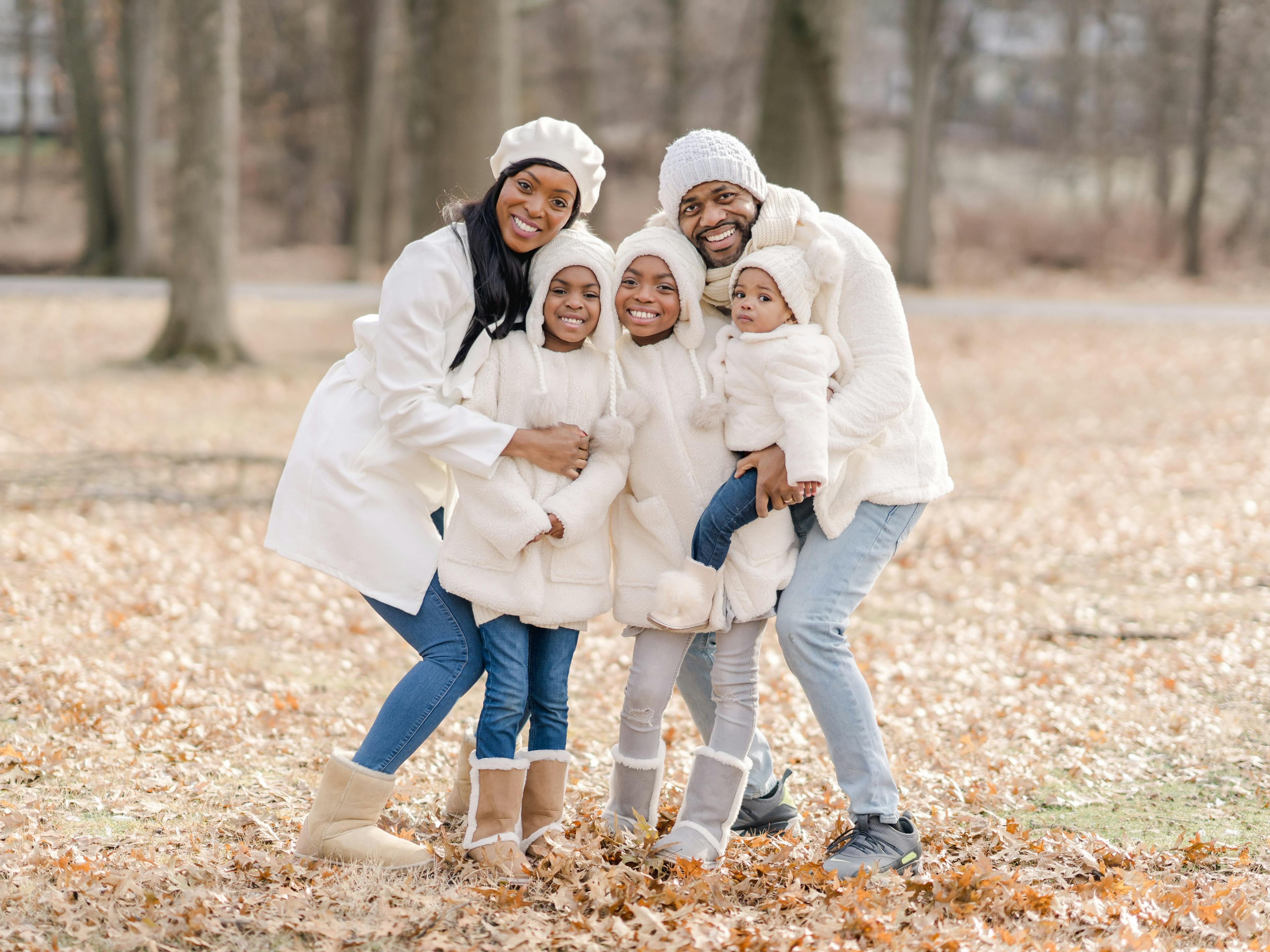 family with three kids in winter clothes posing for a holiday photoshoot