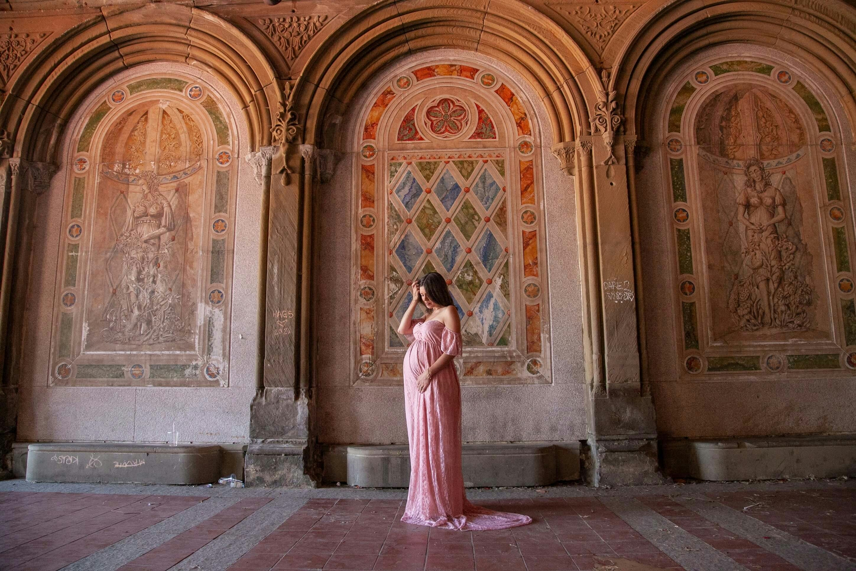 pregnant woman posing for a photoshoot in front of frescoes
