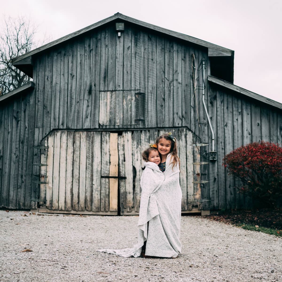 two children in front of a barn