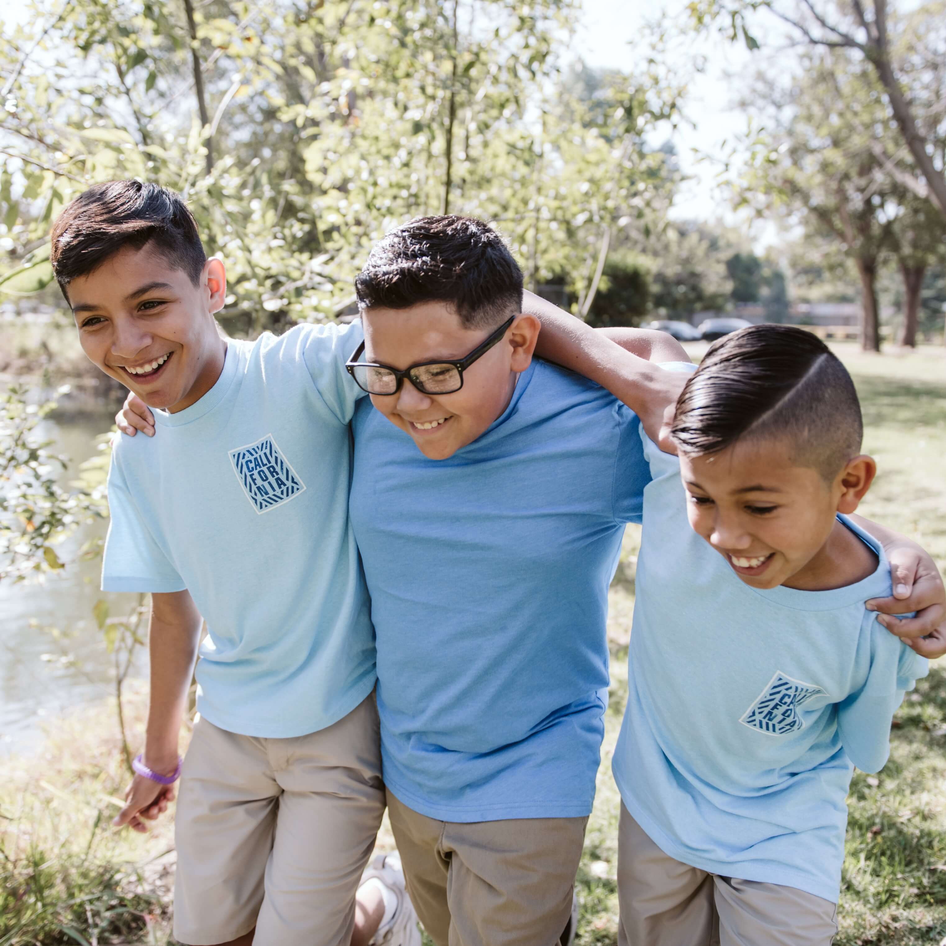 3 boys walking in a public garden.