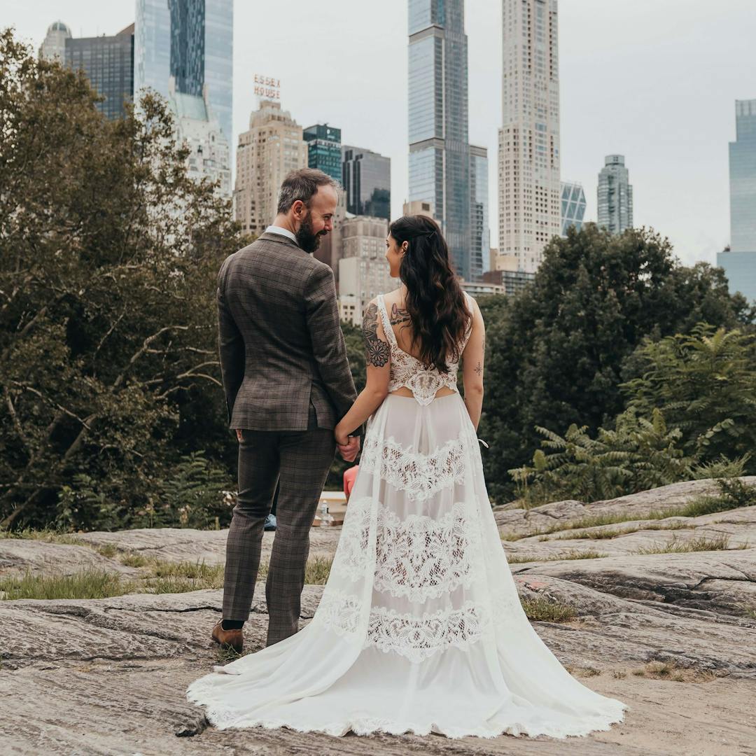man and woman in an engagement dress posing in front of skyscrapers