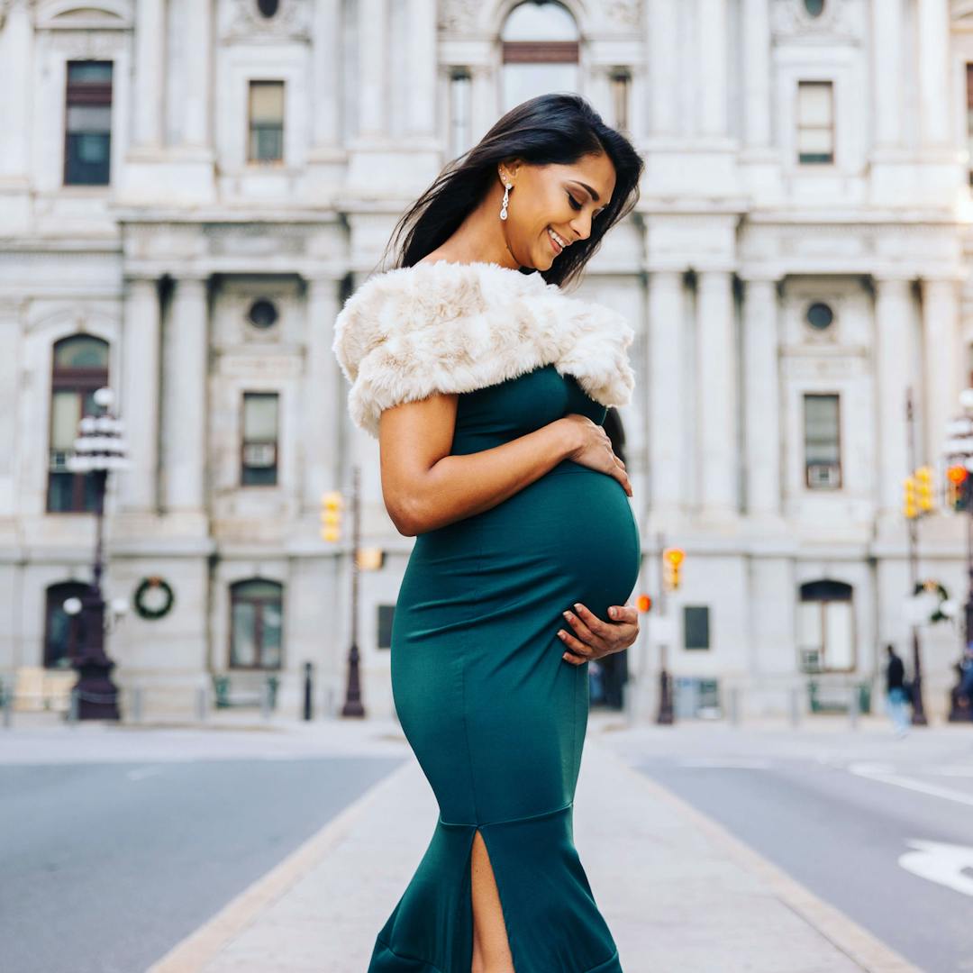 pregnant woman in front of a white building