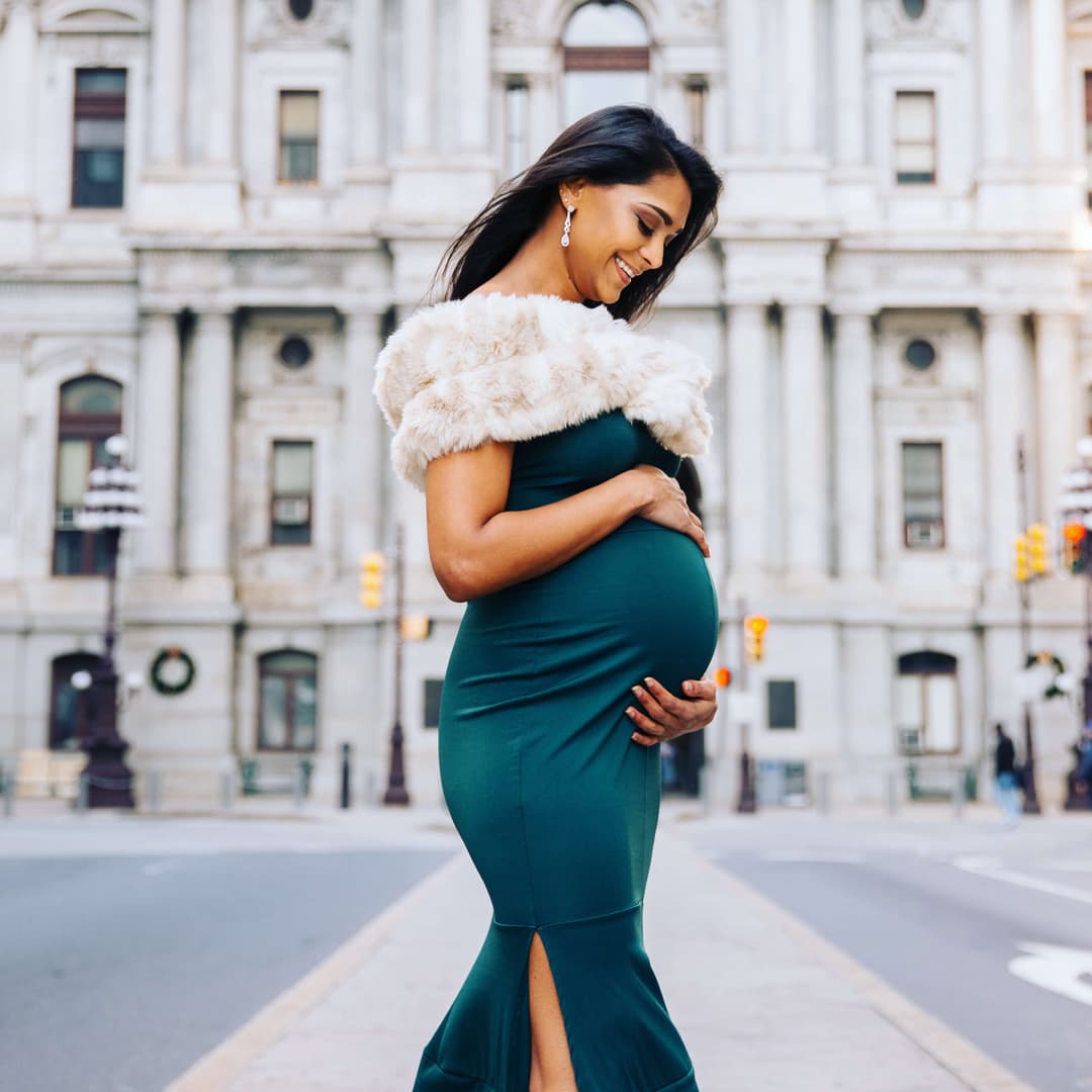 pregnant woman in front of a white building