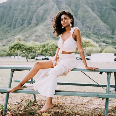 woman in white outfit posing in front of a mountain
