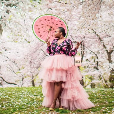 woman with a watermelon umbrella in front of cherry blossoms