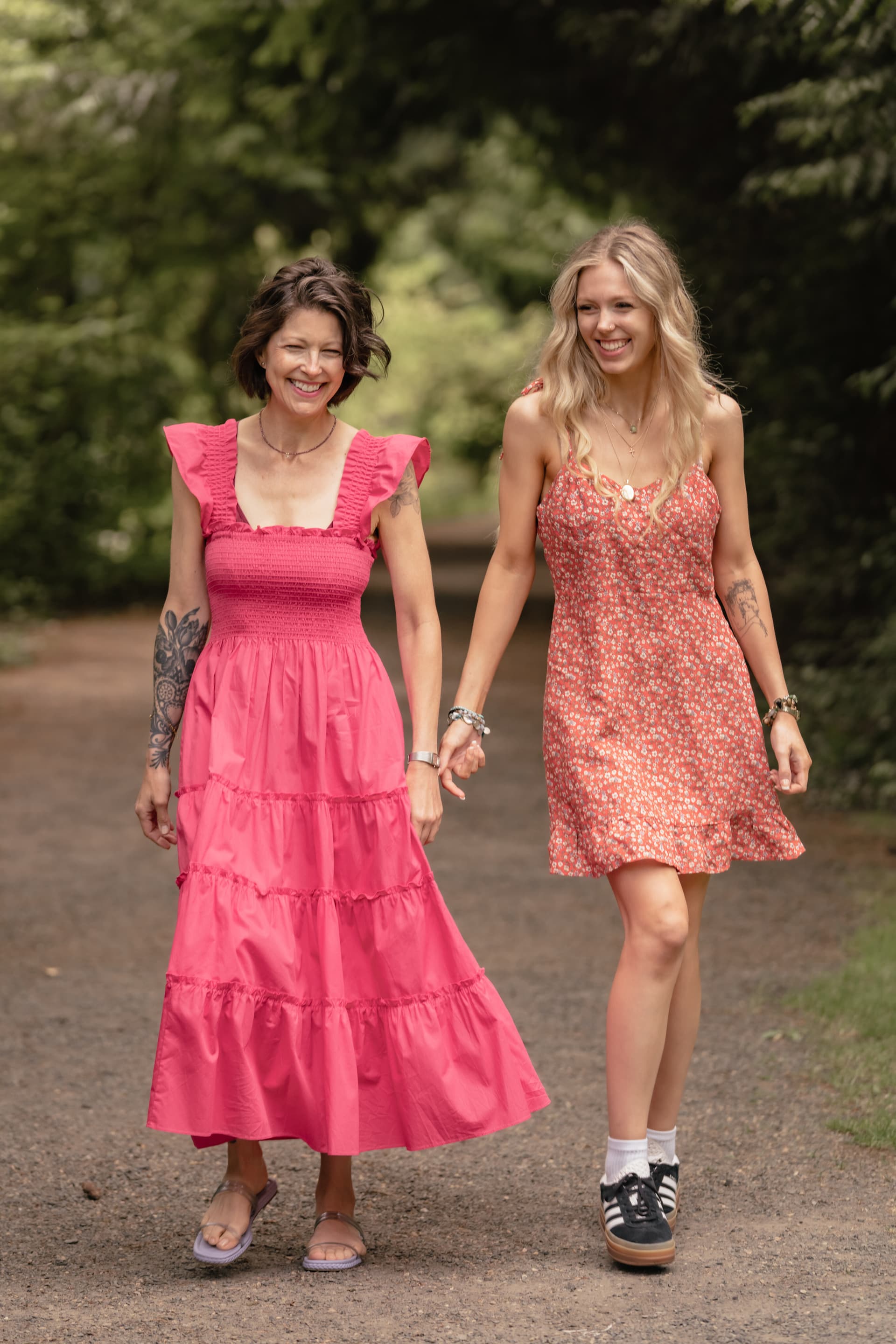 Two women walking together outdoors in bright dresses
