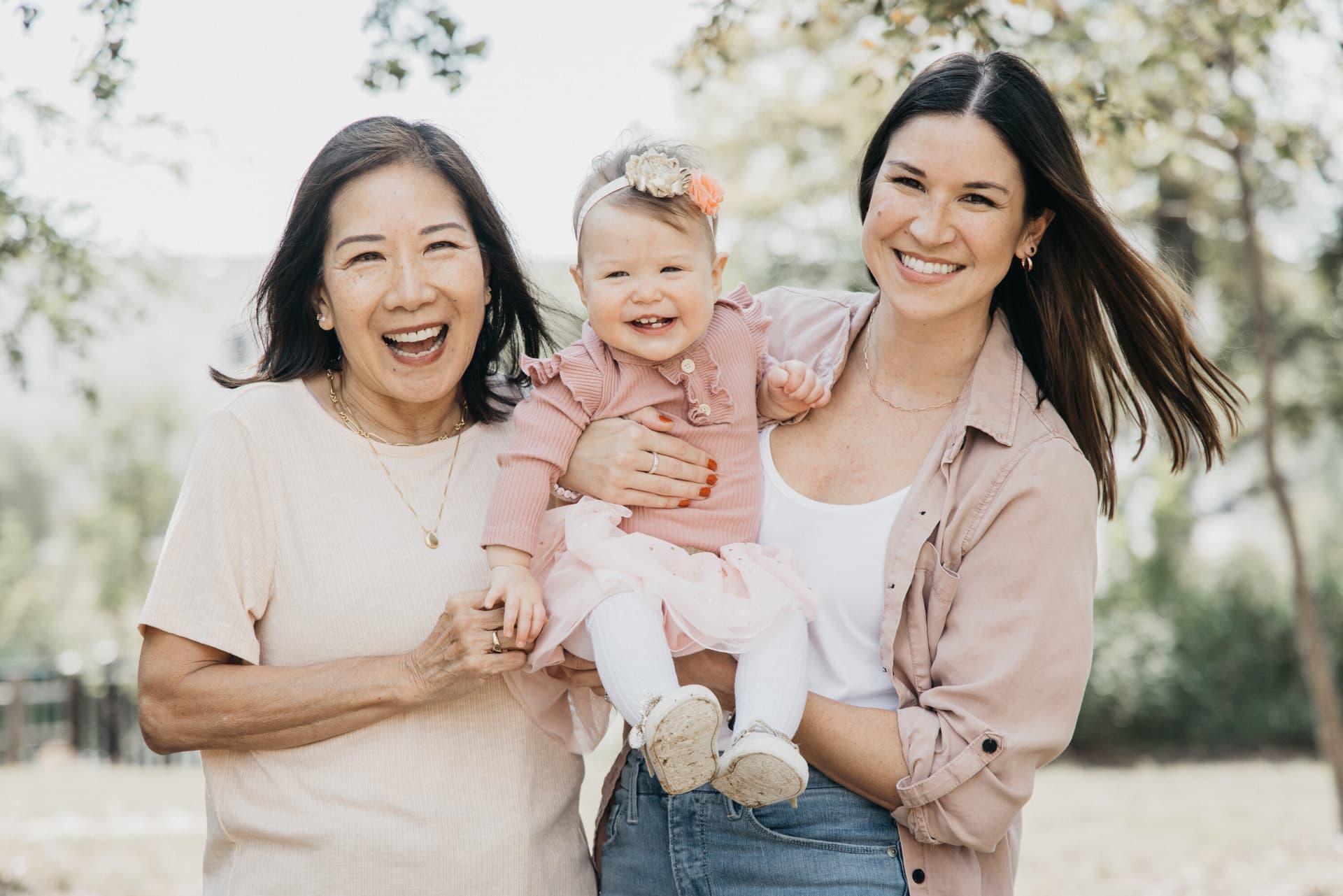 Grandmother, mother, and baby smiling for a family portrait