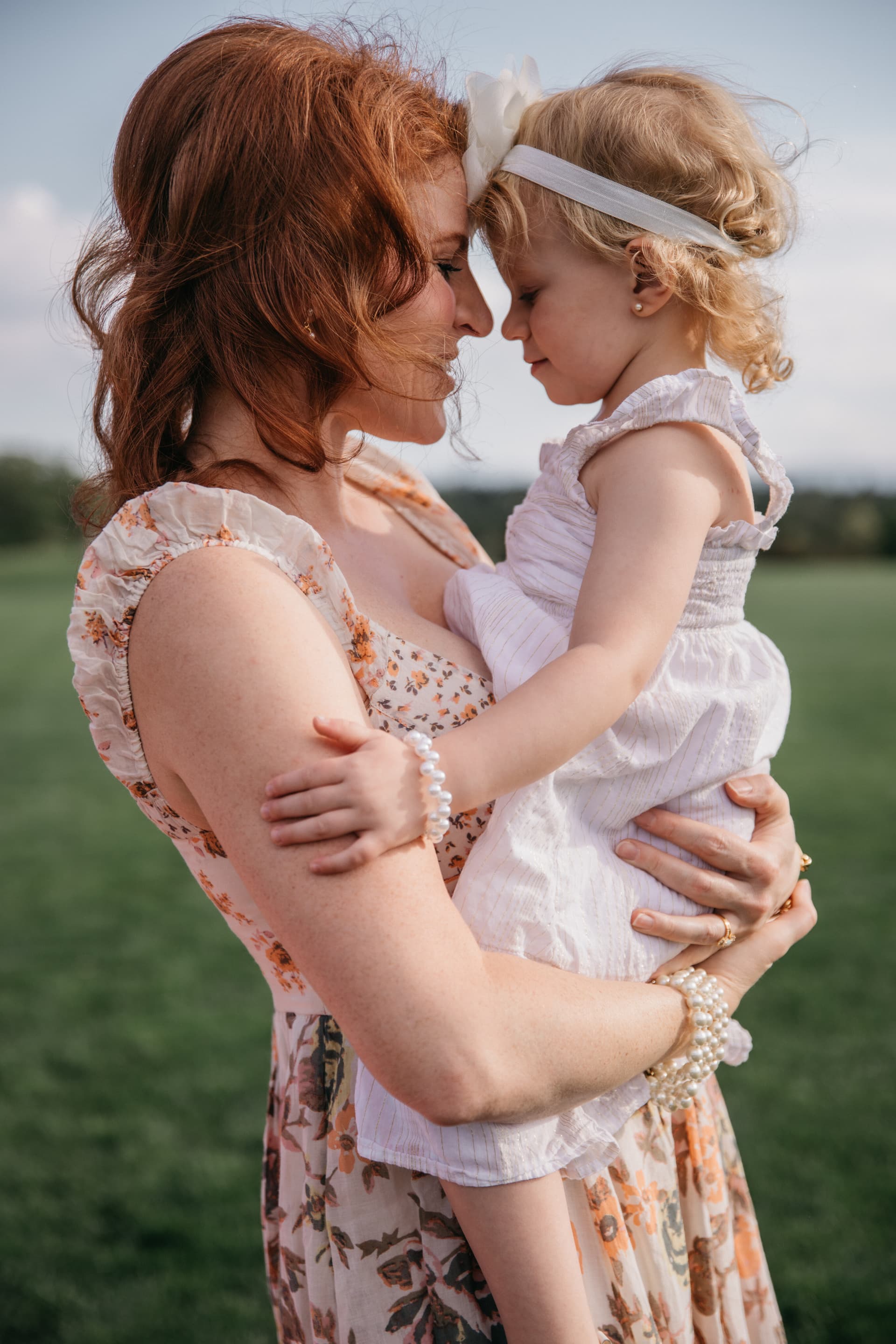 Mother holding her daughter close during an outdoor portrait