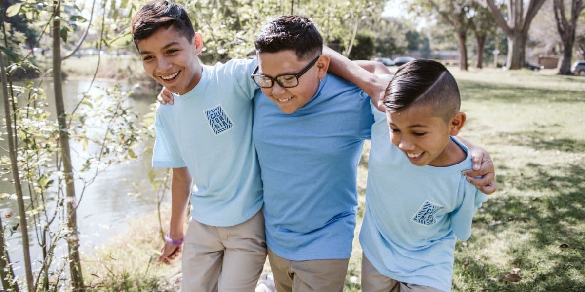 three brothers smile for their park photoshoot