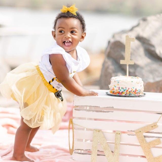 little girl turns one with cake and a birthday photoshoot