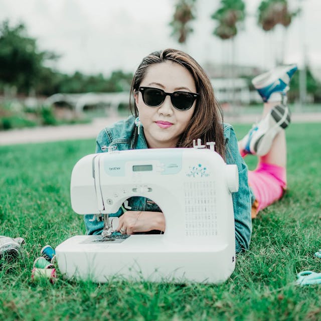 trendy woman poses with her sewing machine in an outdoor park branding photoshoot