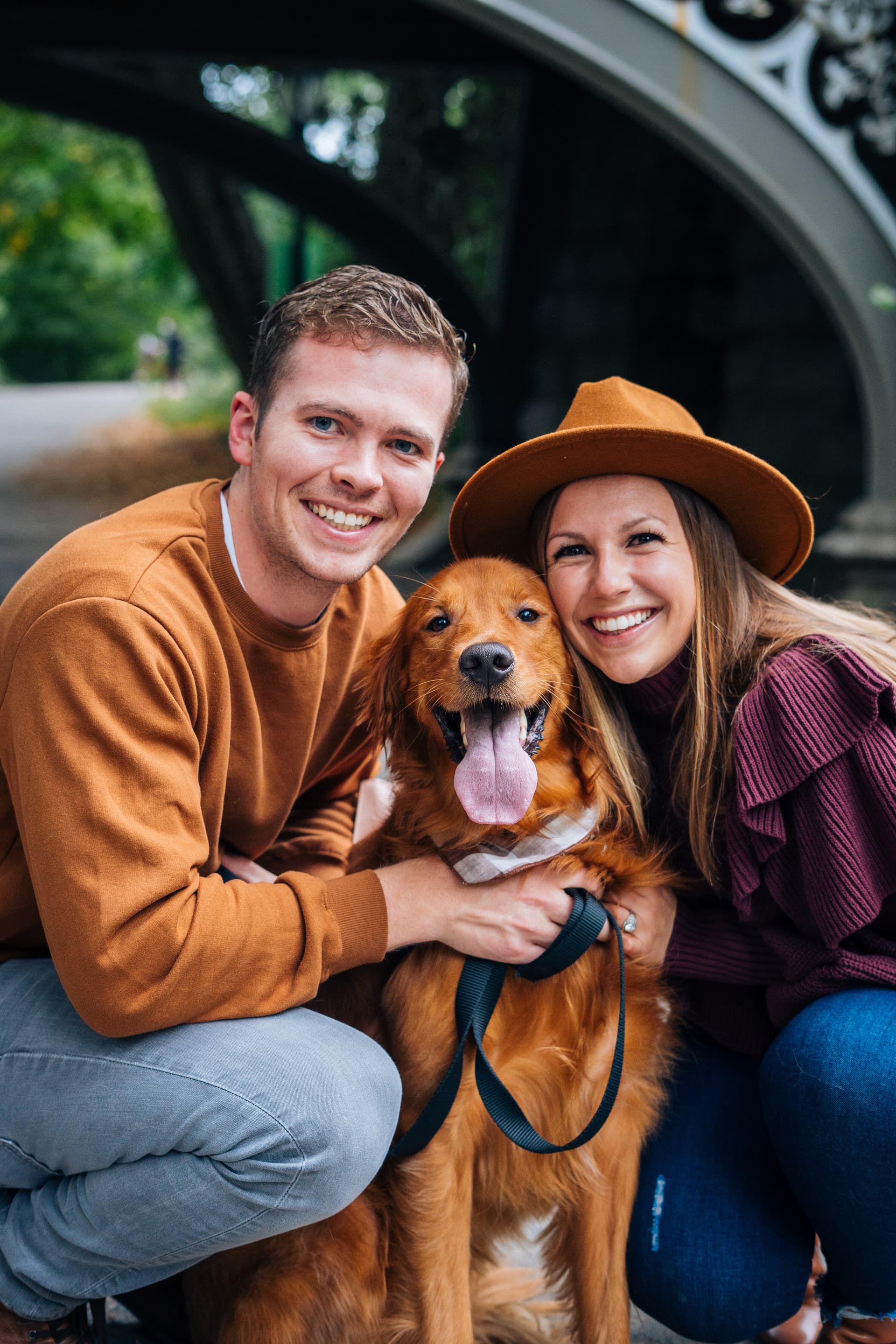 Pet owners smiling with their dog during an outdoor photoshoot