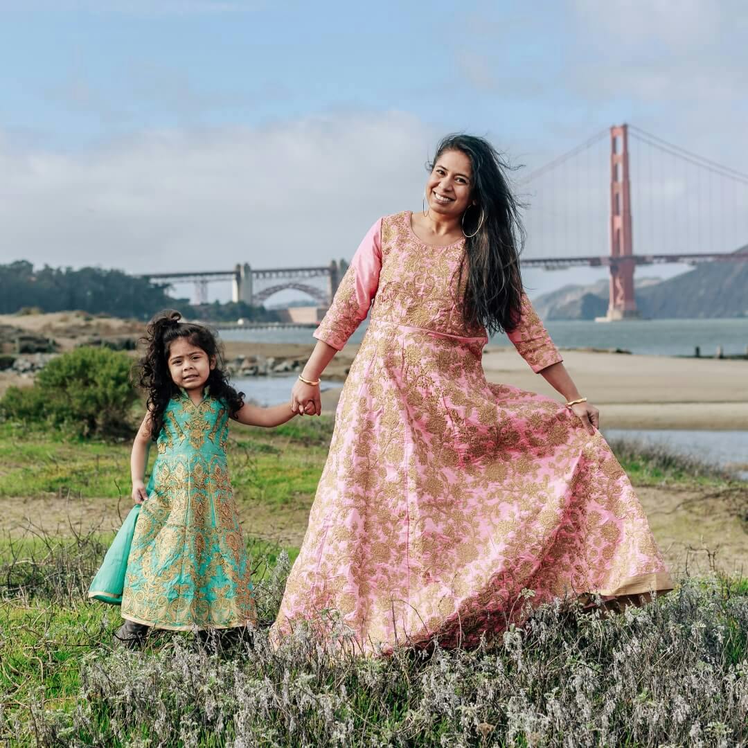 a mother and daughter in front of the Golden Gate bridge