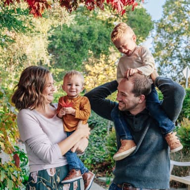 Family with two kids laugh for their free outdoor park photoshoot