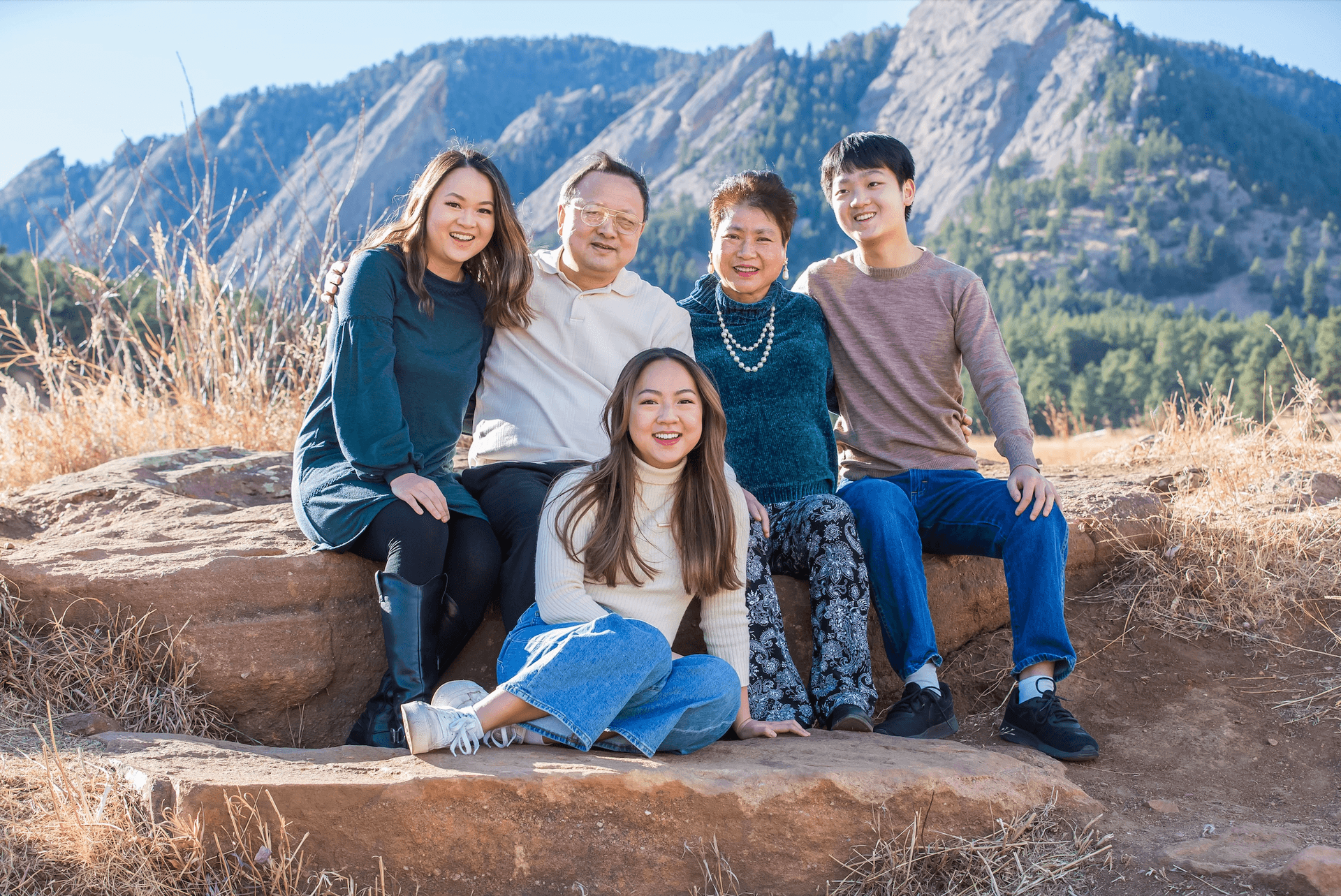 Photo of a family of 5 with mountains as a backdrop in Chautauqua Park in Boulder Colorado.