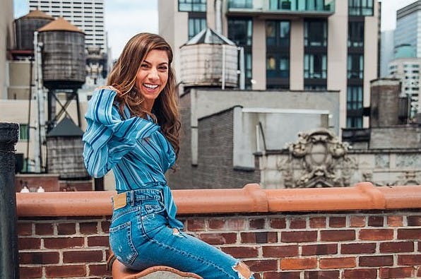 Cheerful woman posing in casual attire on an urban rooftop