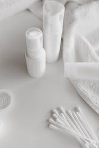 Monochromatic setup of various white artistic pottery and sculptures on a white background.