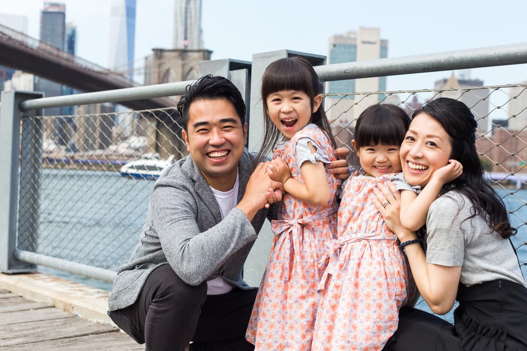 A happy family with two children posing in front of a cityscape.