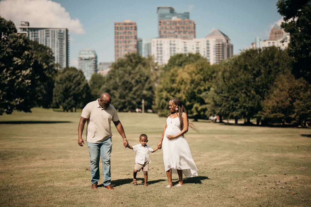 Family session at Piedmont Park with the Midtown Atlanta skyline behind them by a Shoott photographer.