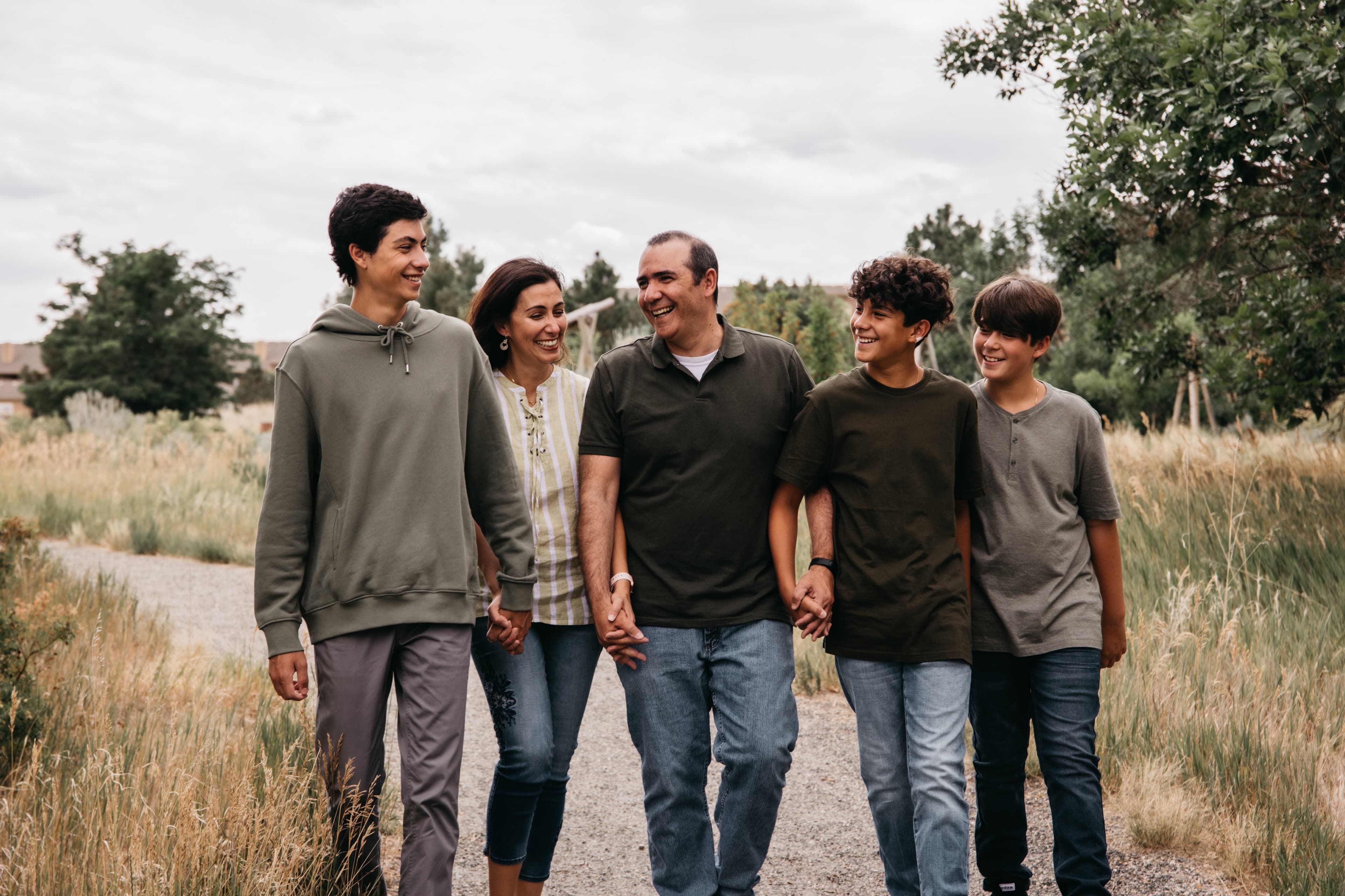 Family of five walking and laughing together on a nature trail