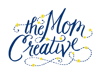 Logo with the text "theMomCreative" in a decorative handwritten font, embellished with small yellow flowers and dots.