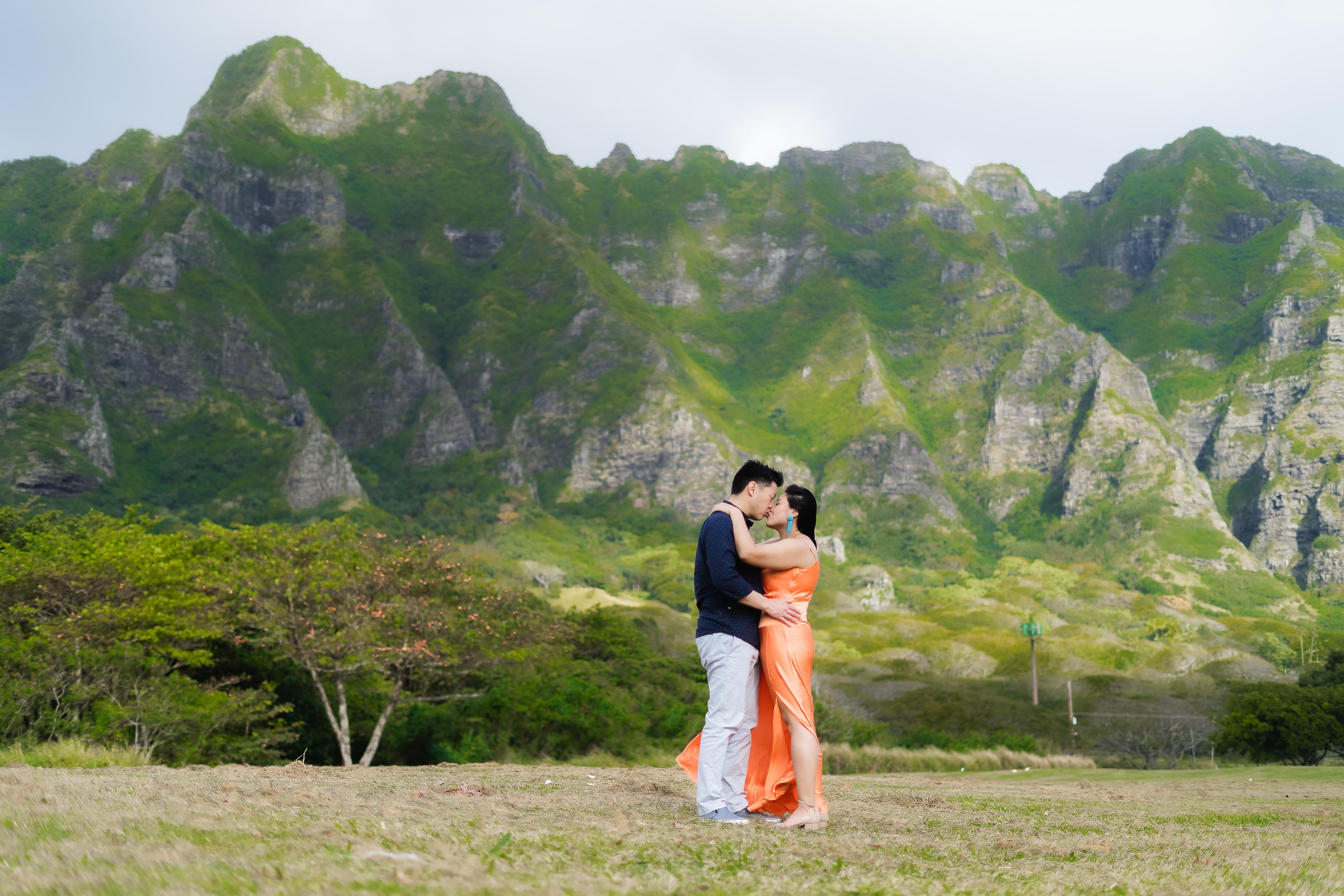 Couple embracing in front of a mountain range.