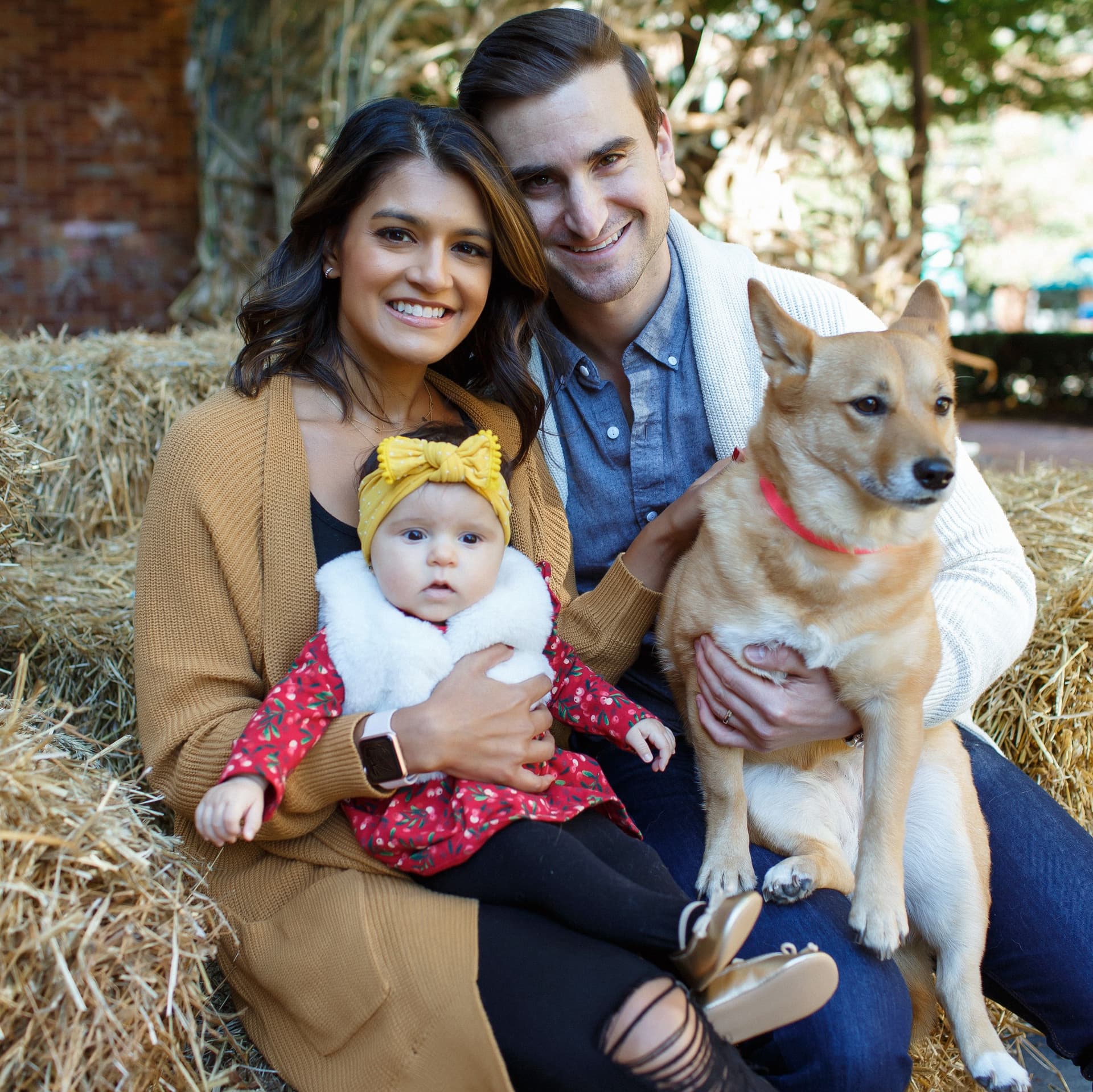 Family dotes on baby girl in front of city skyline for their free outdoor family photoshoot