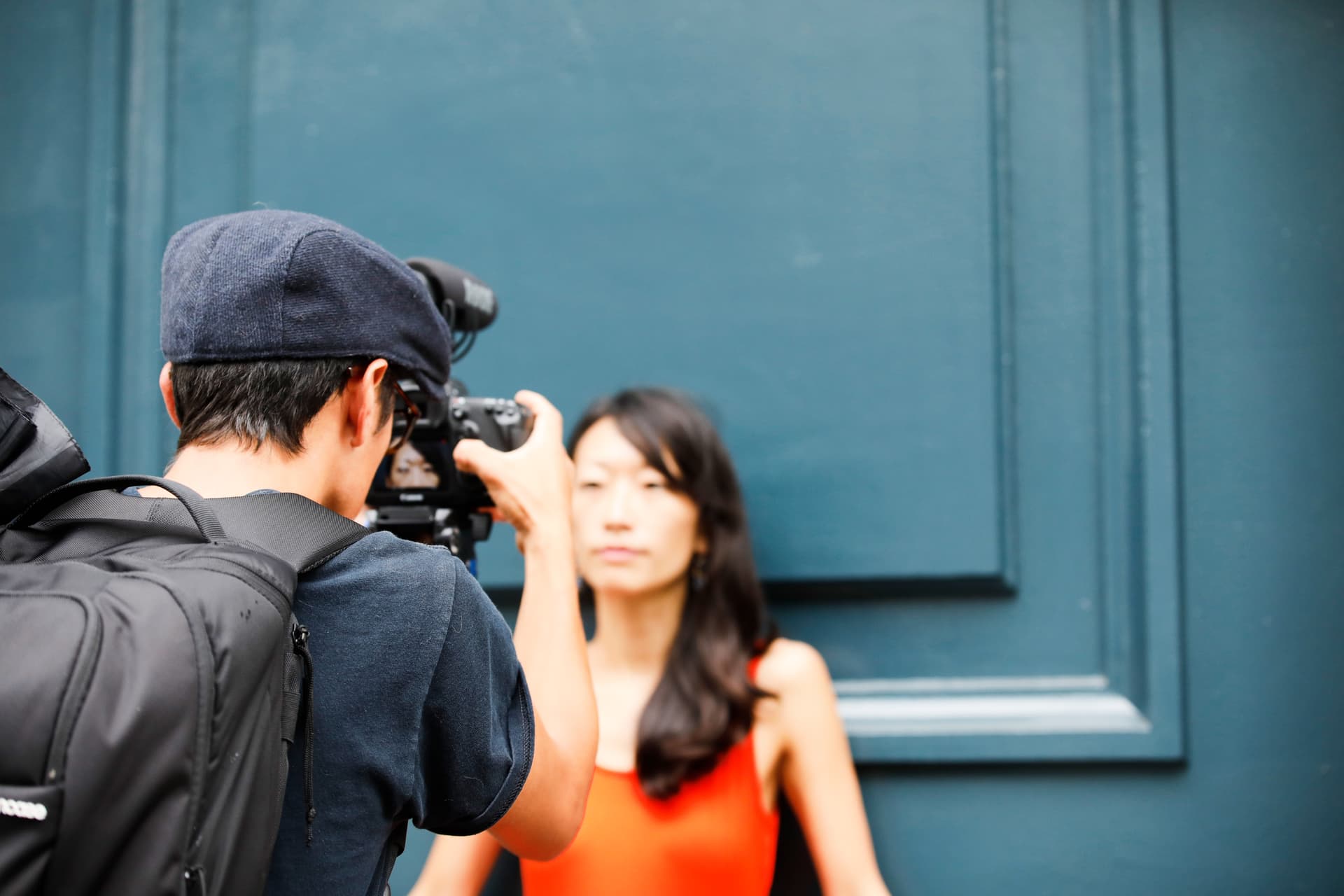 Photographer capturing a woman against a blue background.