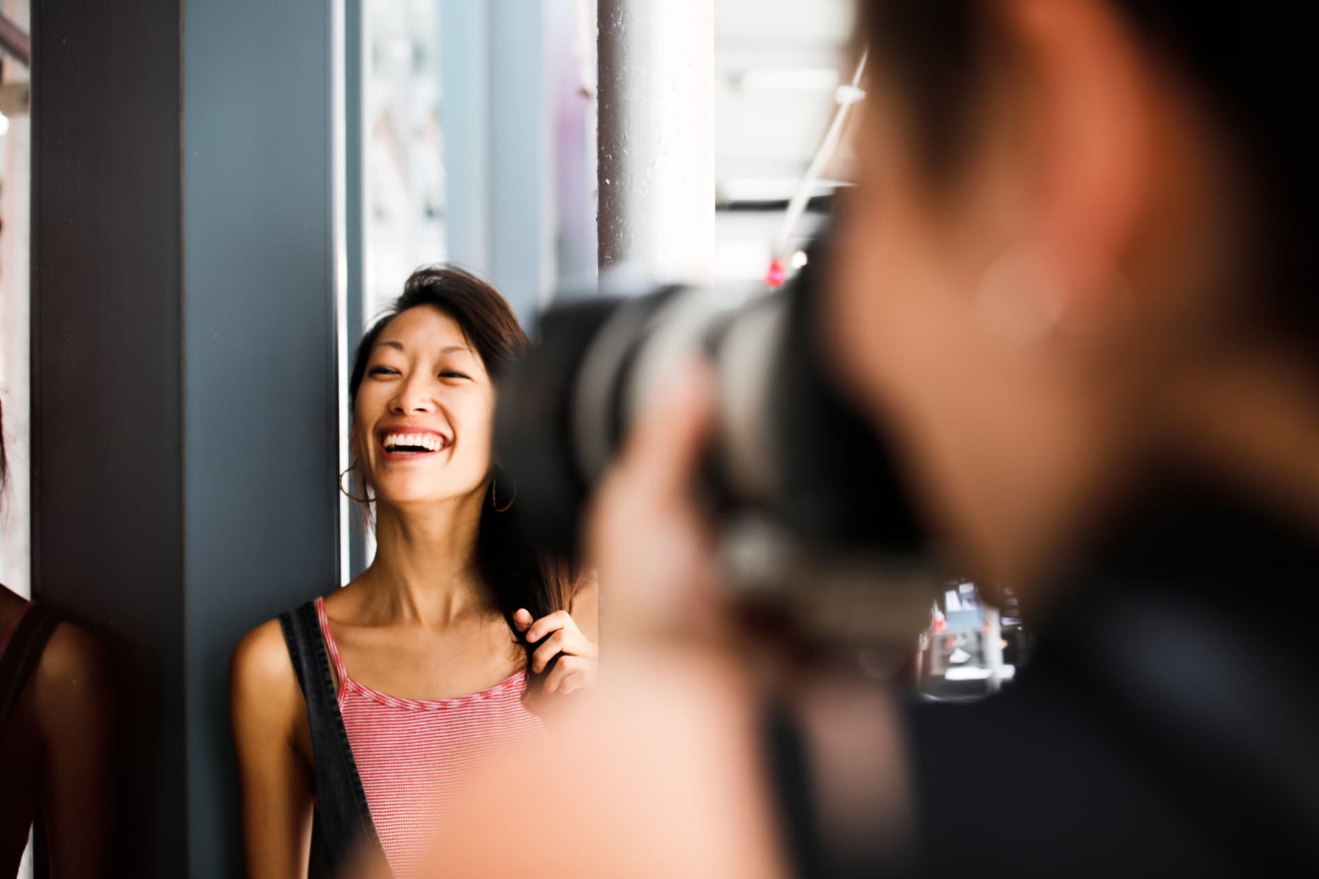 A photographer capturing a joyful woman laughing.