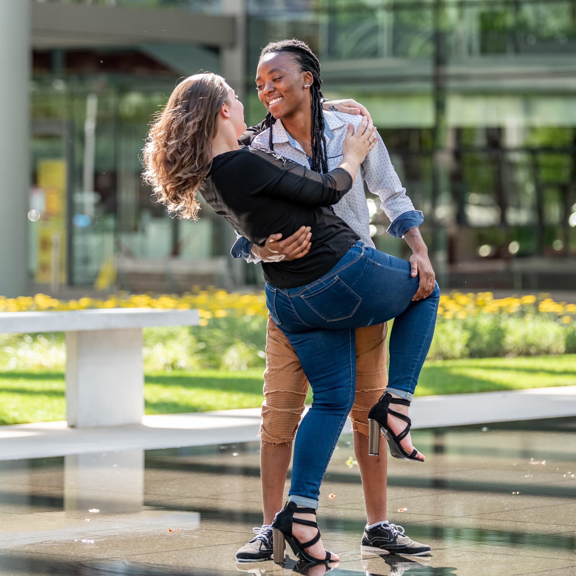 Two women embracing and smiling at each other in an outdoor setting.