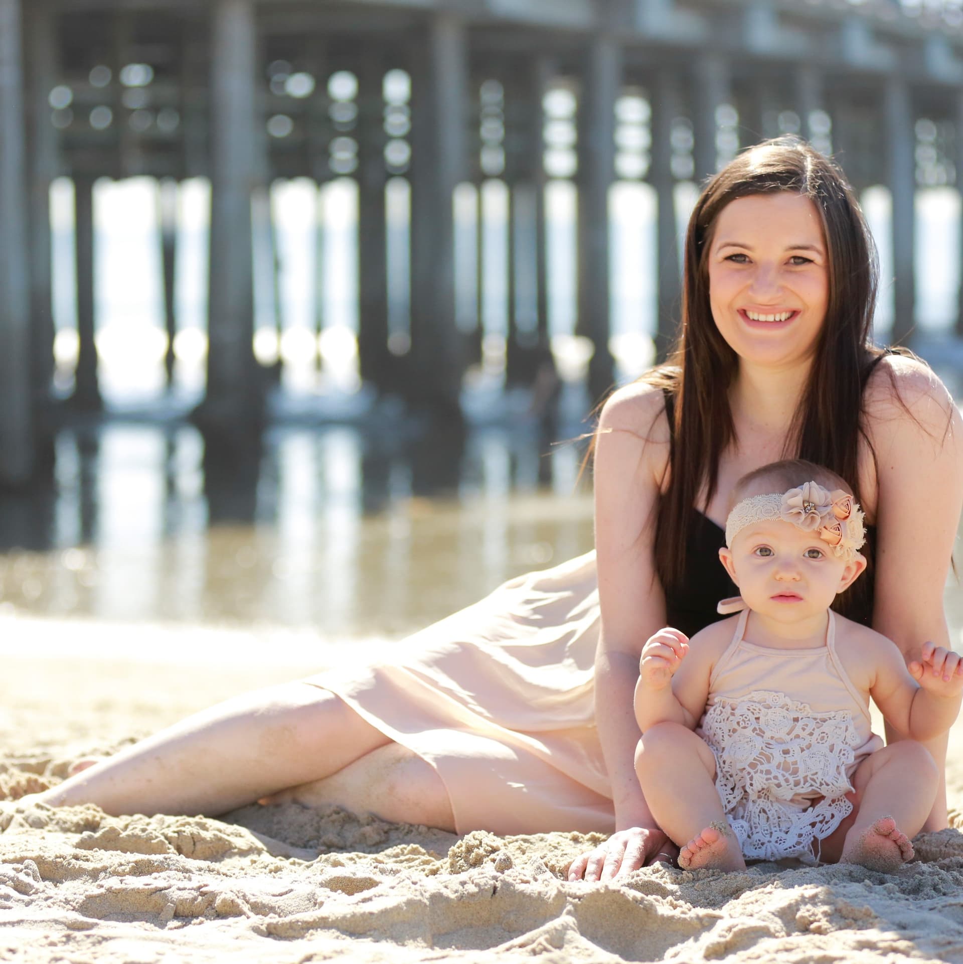 Pregnant woman poses on the beach for her free beach maternity photoshoot