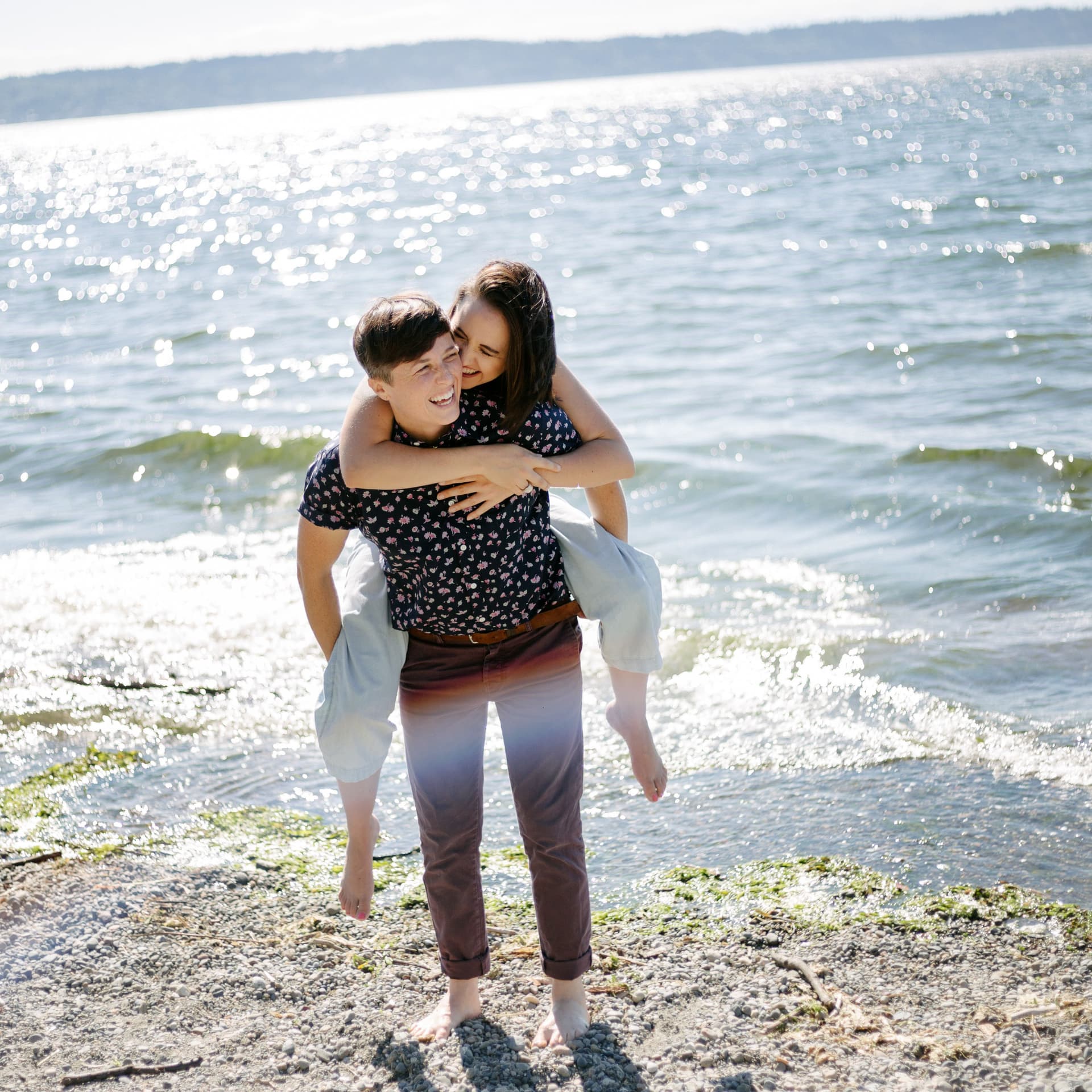 Laughing couple hold each other for their free beach couple photoshoot