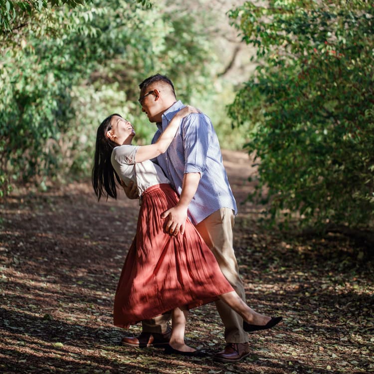 Man dips woman in nature preserve for their free outdoor couple photoshoot