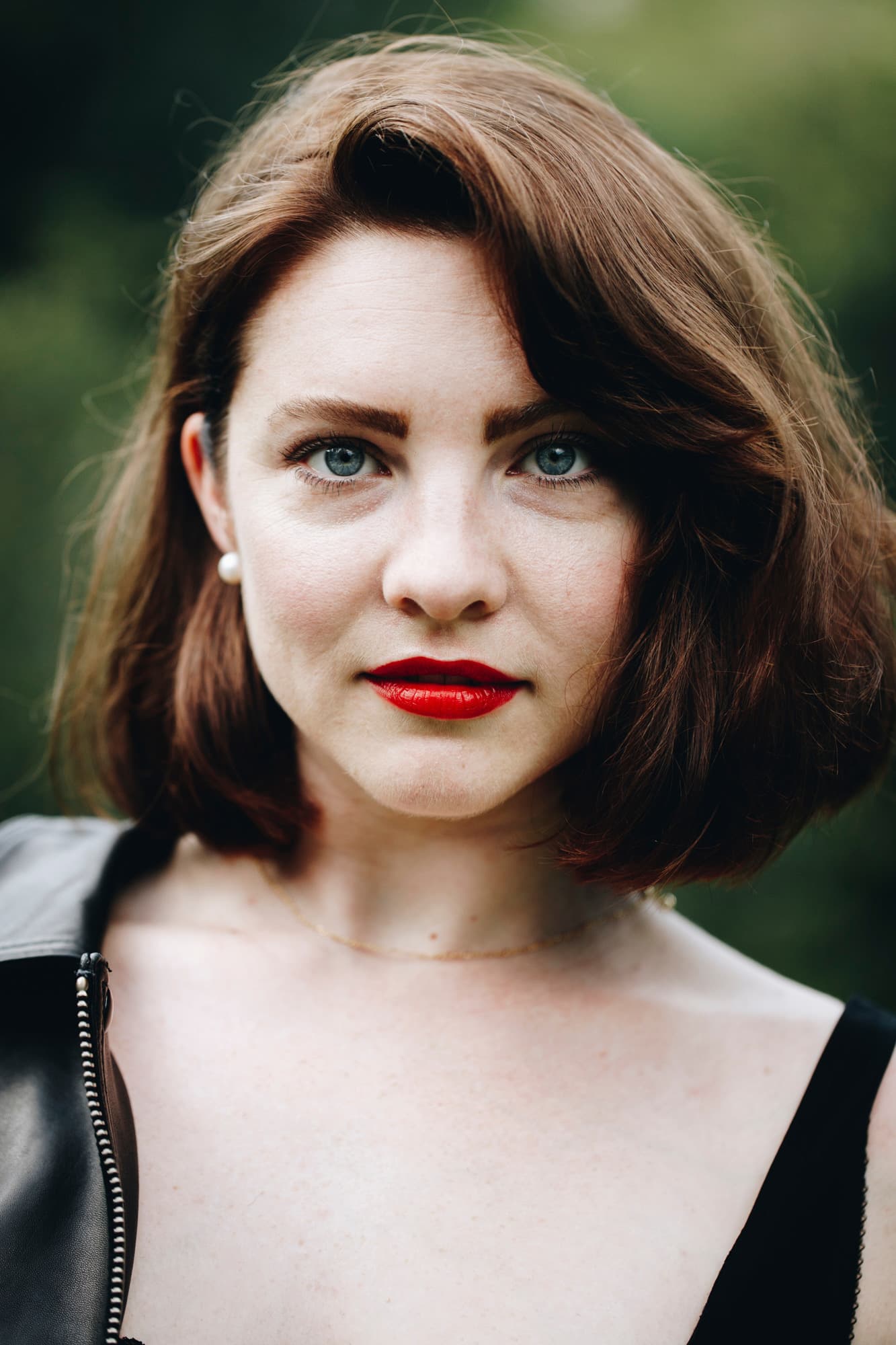 Portrait of a woman with red lipstick and a black top.